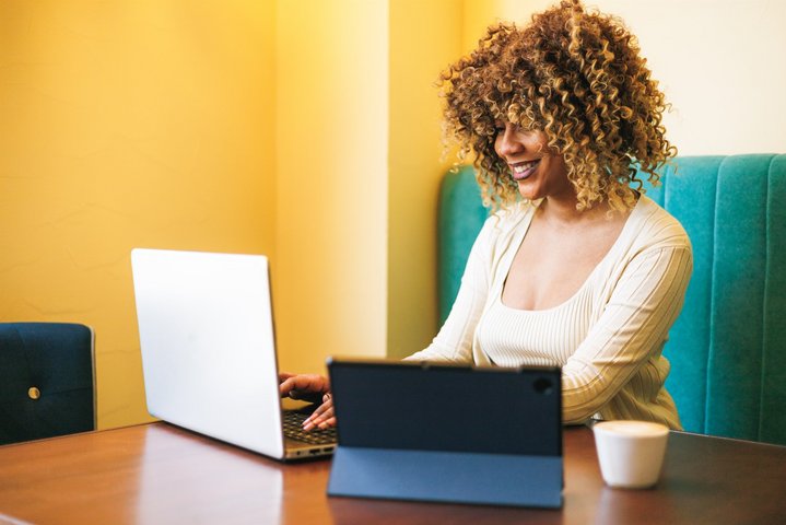 Cafe Productivity Tips for Business Owners: Dominican Girl with Laptop and Tablet in Coffee Shop